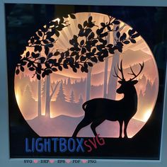 a lighted box with a deer in the woods