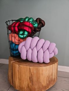 a basket filled with donuts sitting on top of a wooden table next to a pile of doughnuts