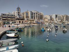 many boats are in the water near buildings