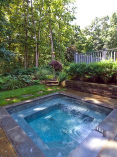 an outdoor hot tub surrounded by lush green trees