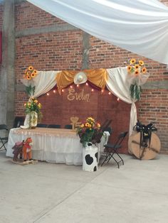 a table with flowers and decorations on it under an awning in front of a brick wall