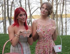 two young women with face paint standing next to each other in front of some trees