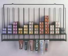 an assortment of lip bales are hanging on a rack with toothpaste tubes