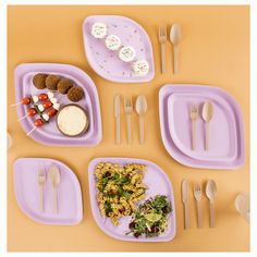 purple plates with food and silverware on yellow tablecloth, arranged in the shape of a rectangle