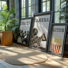 three framed movie posters sitting on top of a wooden floor next to a potted plant