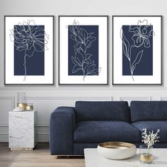 three blue and white paintings in a living room