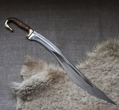 a large knife laying on top of a furry rug