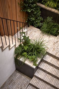 a planter filled with plants sitting on the side of a stair case