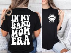 a woman wearing a black shirt with the words in my band mom era on it