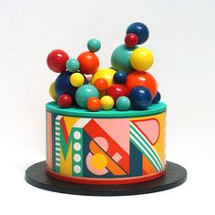 there is a colorful toy in the shape of a can with balls on it and a black base