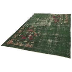 a green rug with floral designs on the top and bottom, in front of a white background