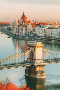 a bridge spanning over a river with buildings in the background