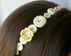 a woman with brown hair has buttons in her hair