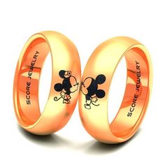 two gold wedding rings with mickey and minnie mouse designs on them, one is for each other