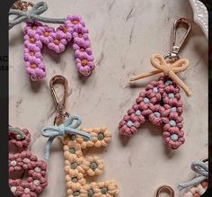 four crocheted keychains sitting on top of a marble counter next to each other