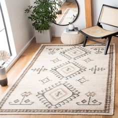 a room with a chair, mirror and rug on the floor in front of it