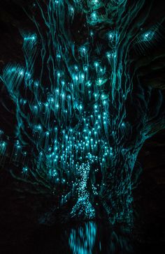 the inside of a cave filled with lots of lights and water flowing down it's walls