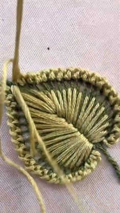 a close up of a piece of cloth with yarn on it and two knitting needles