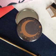 a compact mirror sitting on top of a table next to a brush