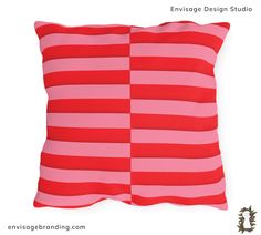 a pink and red striped pillow sitting on top of a white wall