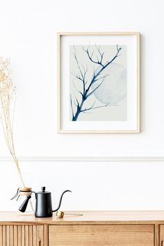 there is a painting hanging on the wall next to a coffee pot and watering can