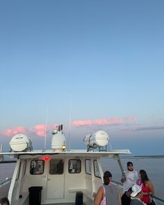 people are sitting on the back of a boat