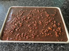 a pan filled with chocolate and pecans on top of a counter