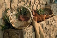 some baskets and plants are sitting on a stone wall