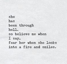 an old typewriter with the words she has been through hell so believe me when i say, fear her when she looks into a fire and smiles