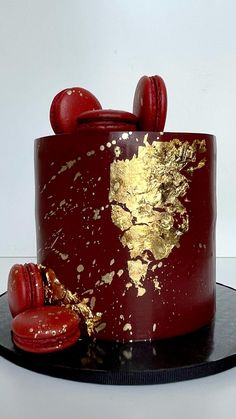 a red and gold cake on a black plate