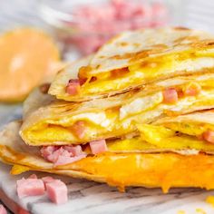 two quesadillas stacked on top of each other with ham and cheese in the middle