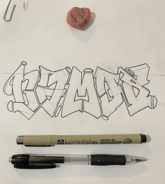 some type of graffiti written on a piece of paper next to a pen and marker