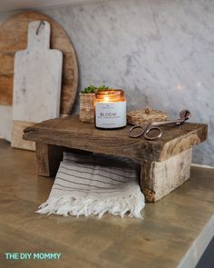 a candle sits on a table next to some scissors and other items that are sitting on top of it