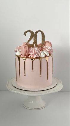 a pink cake with gold numbers and flowers on top