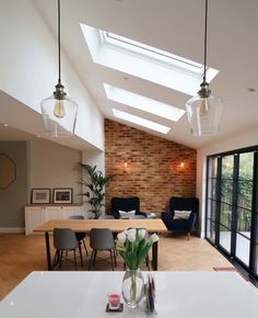 an open living room and dining area with skylights