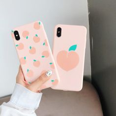 a woman holding two pink iphone cases with peaches on them