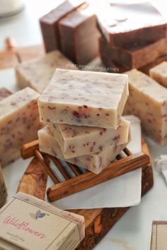 several bars of soap sitting on top of a wooden cutting board next to cinnamon sticks