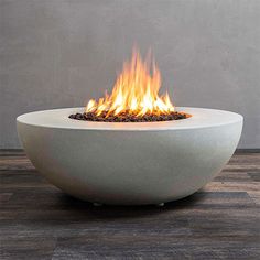 an outdoor fire pit sitting on top of a hard wood floor next to a wall