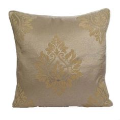 a gold and silver pillow with an ornate design on the front, sitting against a white background