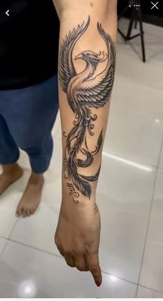 a person with a tattoo on their arm and foot is standing in front of a tile floor