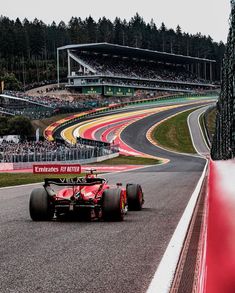 a man driving a red race car down a track