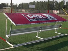 a red and white sign on the side of a field that says go for it