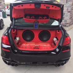 the back end of a black car with its trunk open and speakers in it's trunk