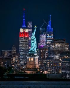 the statue of liberty is lit up in red, white and blue for new york