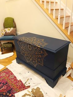 a large blue box sitting on top of a wooden floor next to a stair case