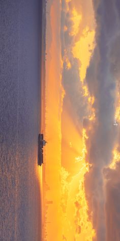 the sun is setting behind some clouds on the water and it looks like they are floating in the ocean