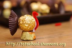 there is a chocolate candy on top of a small gold shell with a red hat