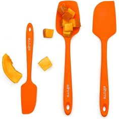 three orange spatulas and two pieces of fruit