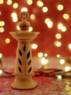 a small wooden candle holder with lights in the background