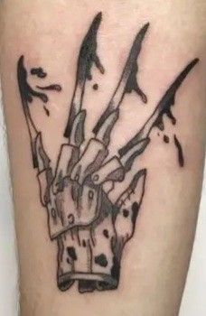 a black and white tattoo on the leg of a person with knifes in their hands